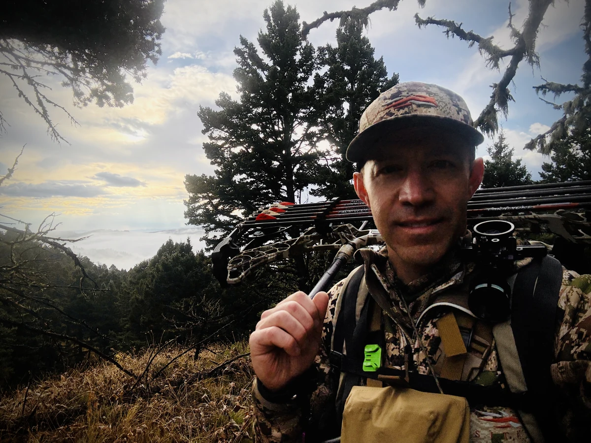 Adam Callinan outdoors with archery equipment