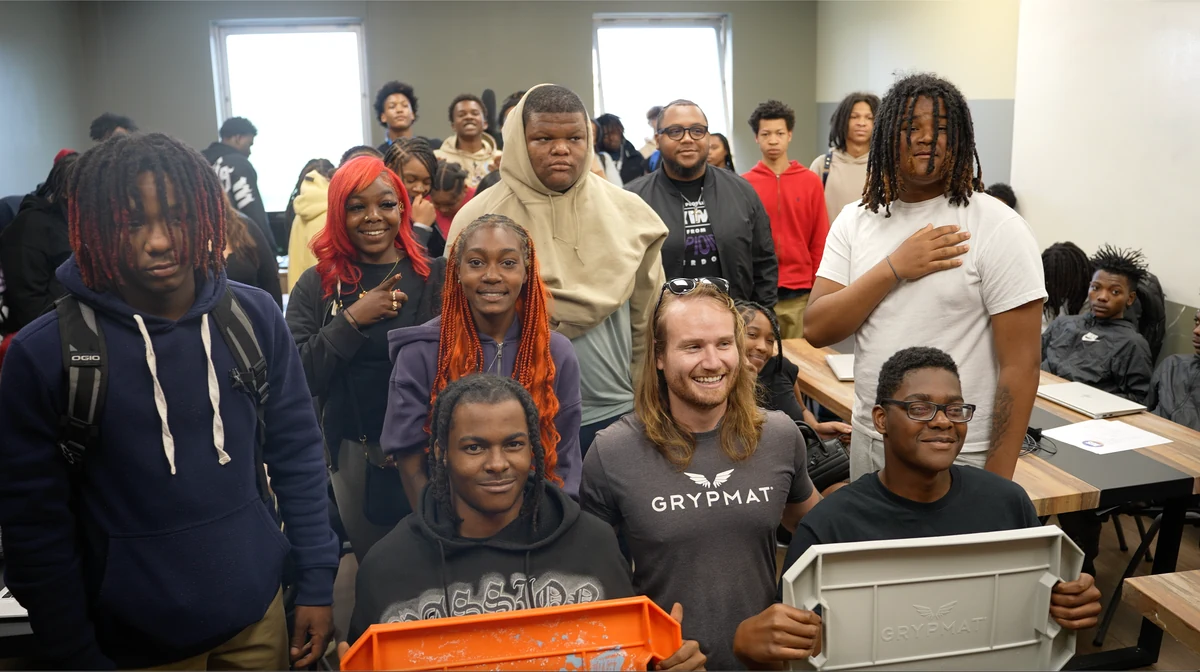 Tom Burden in a Grypmat shirt with students